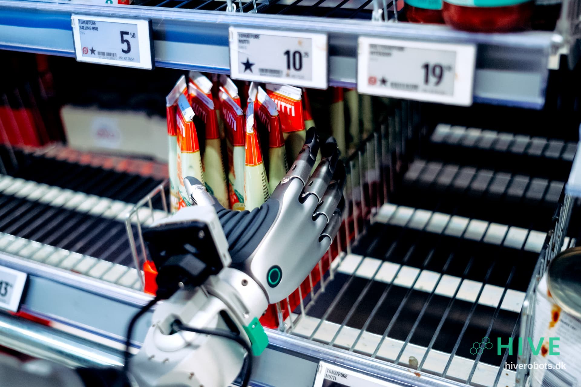 A HIVE robot hand gripping a product on a supermarket shelf